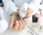 Woman uses manicure machine to treat nails. Home manicure concept